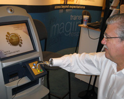 A man with a prosthetic hand types on the accessible keypad of a screened kiosk.